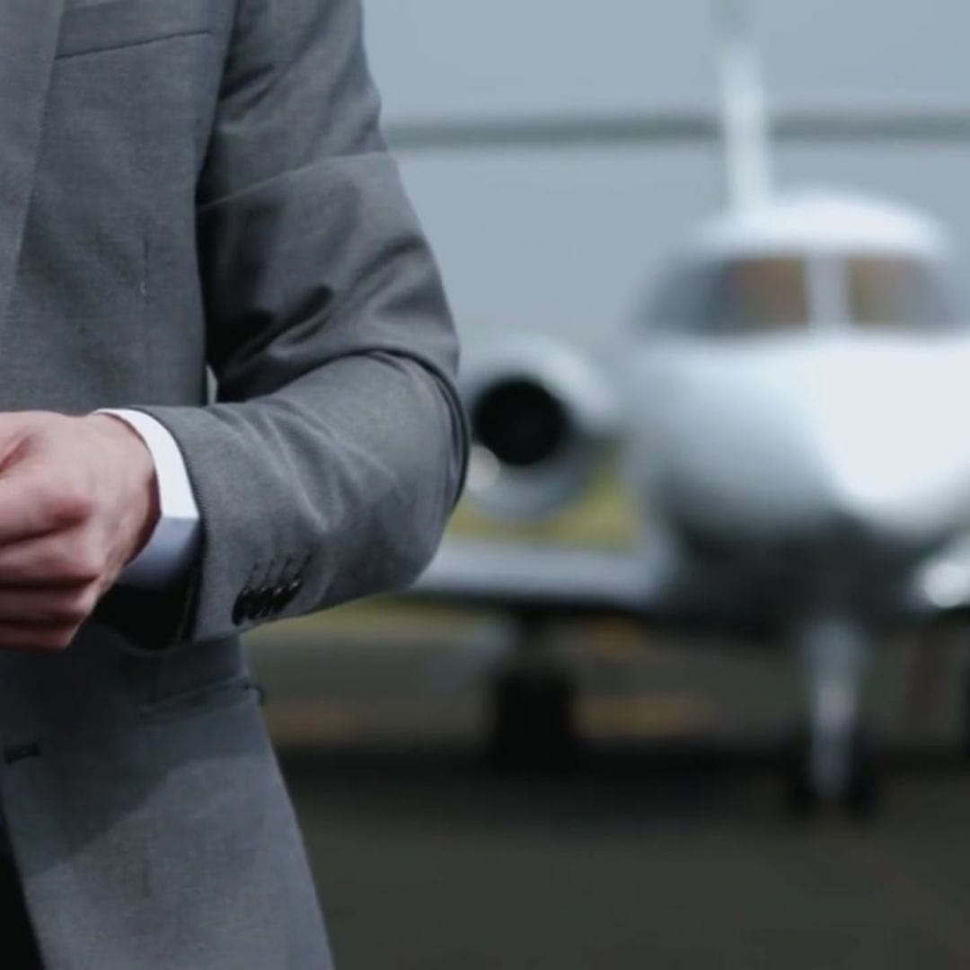Business executive standing in front of a private jet before departure.